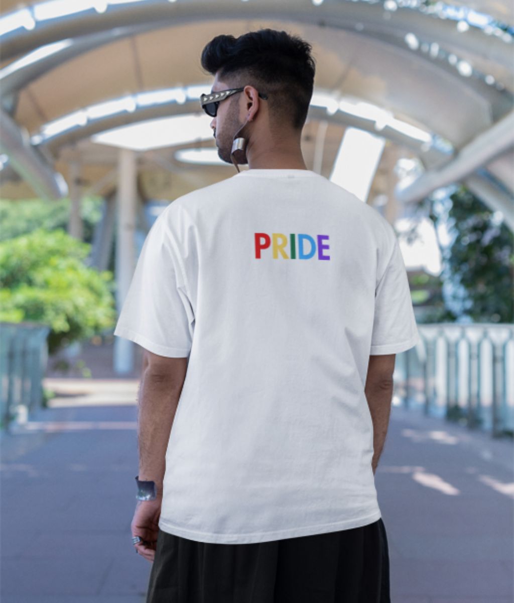 A man stands on a bridge, proudly wearing a pride t-shirt, symbolizing support for the LGBTQ+ community.